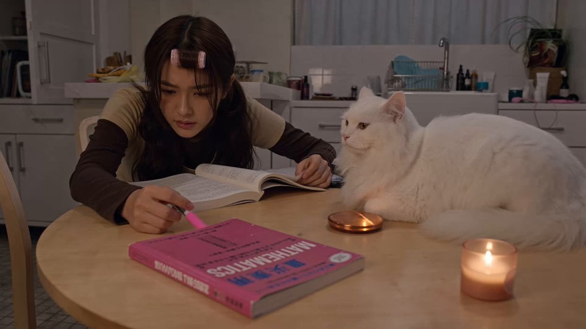 A young woman studies alone at a kitchen table…