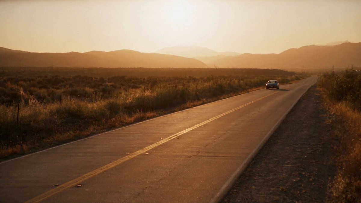 0:00–0:05 — LONELY HIGHWAY Wide cinematic establishing shot of…